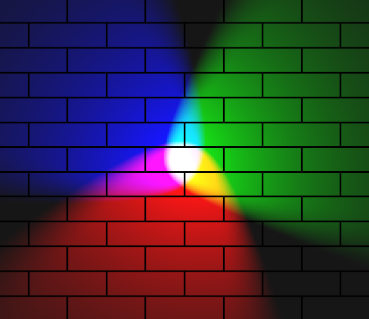 Rainbow spotlights with a white center against a brick wall.